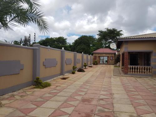 a walkway next to a fence and a building at Rugems Executive Lodge in Lusaka