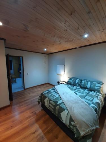 a bedroom with a large bed with a wooden ceiling at Klein Plasie - St Helena Bay in Stompneusbaai