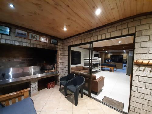 a room with a brick wall with a couch and a chair at Klein Plasie - St Helena Bay in Stompneusbaai