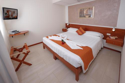 a hotel room with a bed with towels on it at Hotel Michelangelo in Terranuova Bracciolini