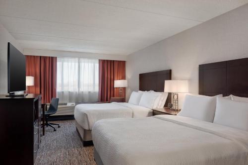 a hotel room with two beds and a flat screen tv at Garner Hotel Wadsworth by IHG in Wadsworth