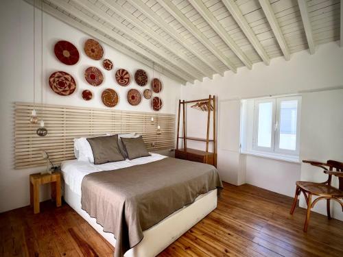 a bedroom with a bed and plates on the wall at Villa Nooma Elvas in Elvas