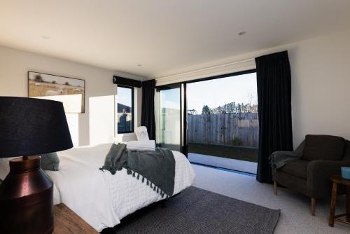 a bedroom with a bed and a large window at Alpine Retreat in Methven