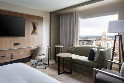 a hotel room with a couch and a tv at San Antonio Marriott Rivercenter on the River Walk in San Antonio