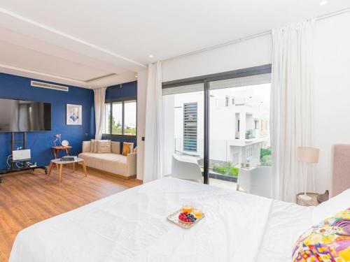 a bedroom with a white bed and a living room at Villa Séréna Pool and Comfy in Tamaris