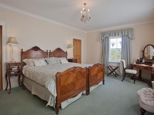 a bedroom with a large bed and a desk at West Longridge Manor B&B in Berwick-Upon-Tweed