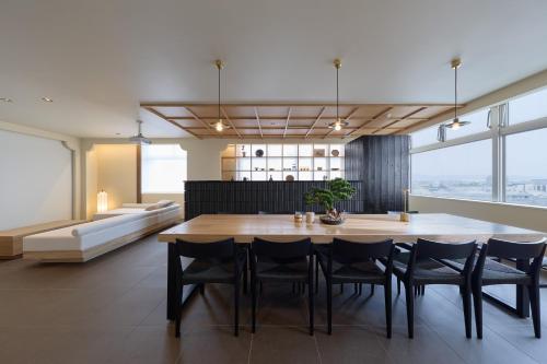 a dining room with a large wooden table and chairs at AO Odawara Lounge in Odawara