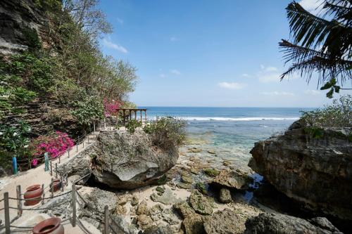 a staircase leading to the beach with the ocean at The Island Houses Bingin in Uluwatu