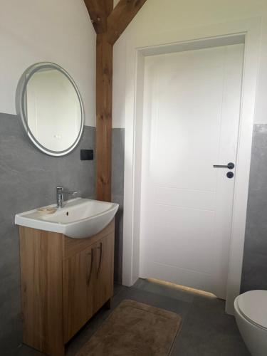 a bathroom with a sink and a mirror and a toilet at Chill and Grill Apartment in Wola Smolana