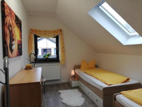 a bedroom with a bed and a desk and a window at Pension & Ferienwohnung Eitler in Aue-Bad Schlema