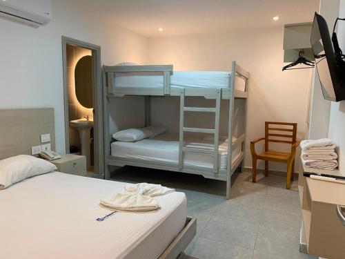 a bedroom with two bunk beds and a chair at Hotel San Sebastian Real in Cartagena de Indias