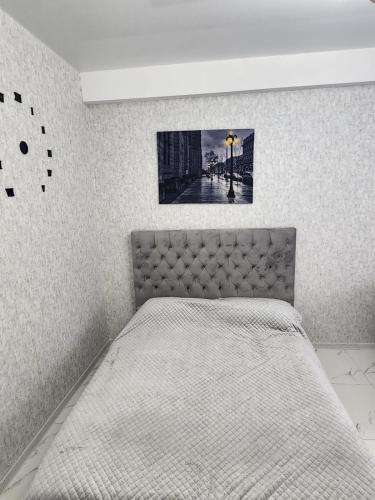 a bedroom with a bed with a picture on the wall at bakuriani mix 504 in Bakuriani