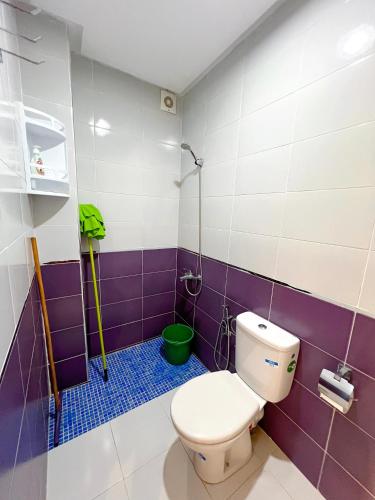 a bathroom with a toilet and purple and white tiles at Visit Chamal - Palmera 3 in Oued Laou