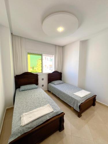 a bedroom with two beds and a window at Visit Chamal - Palmera 3 in Oued Laou