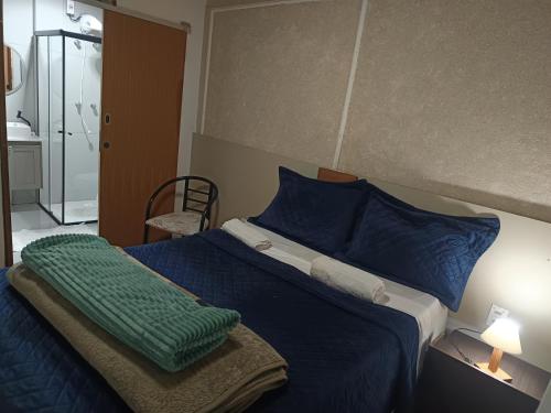 a bedroom with a bed with a green blanket on it at Vista do pico Itacolomi in Ouro Preto