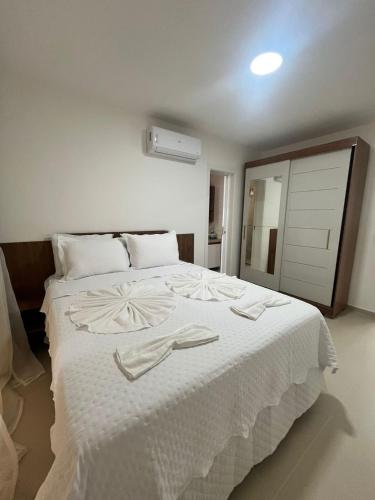 a bedroom with a large white bed with white sheets at Canoa Breeze - Beach Front in Canoa Quebrada