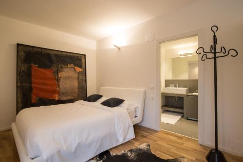 a bedroom with a white bed and a bathroom at Casa Marchiodi in Trento