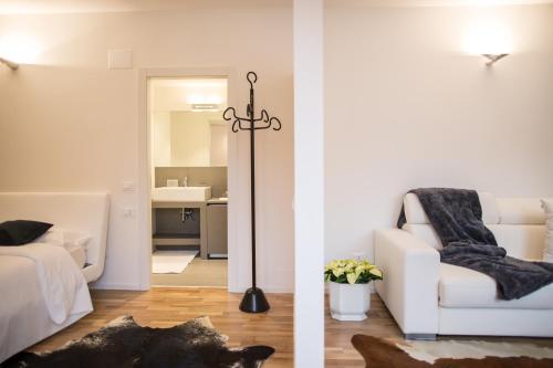 a living room with a white couch and a white chair at Casa Marchiodi in Trento