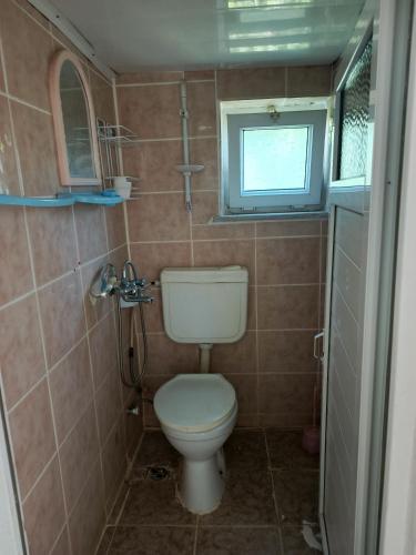 a small bathroom with a toilet and a window at Ocaklar Torunlar Apart in Erdek