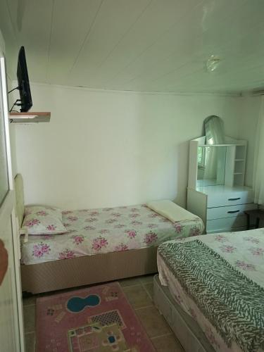 a small bedroom with two beds and a dresser at Ocaklar Torunlar Apart in Erdek