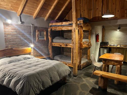 a bedroom with two bunk beds and a table at Bolson deptos in El Bolsón