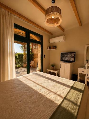 a bedroom with a large bed with a large window at La Hacienda Ras Sedr in Ras Matarma
