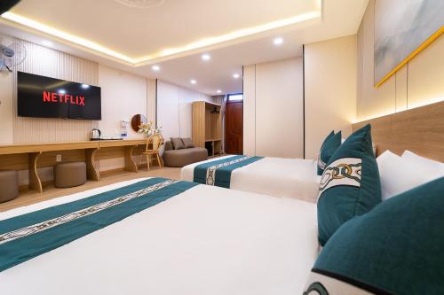 a hotel room with two beds and a television at Green Airport Hotel 2 in Ho Chi Minh City