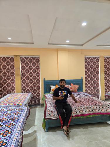 a man sitting on a bed in a room at Musafir Desert Camp Jaisalmer in Jaisalmer