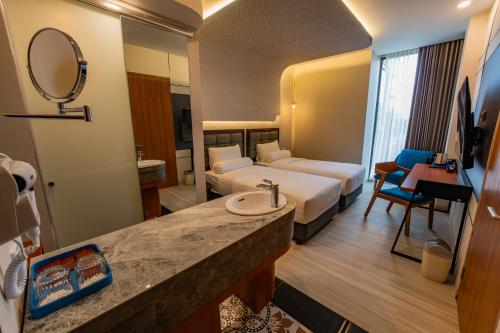 a hotel room with a bed and a bathroom with a sink at Azana Boutique Hotel Solo in Purwosari