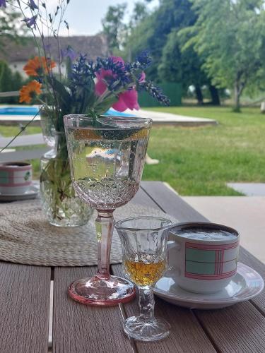 a table with two wine glasses and a cup on it at 3a kuca Bajevac in Bajevac