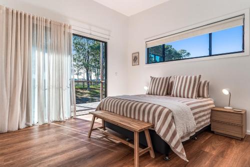 a bedroom with a bed and a large window at Fernleigh Stay in Fernleigh