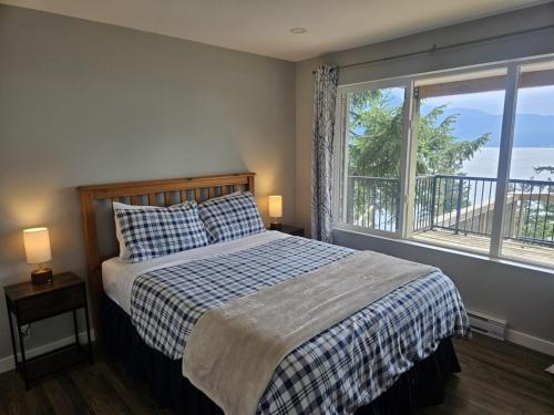 a bedroom with a bed and a large window at Howe Sound View in Bowen Island