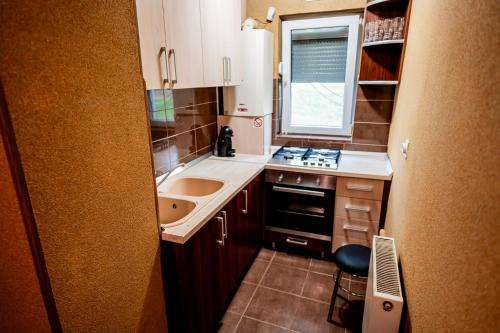 a small kitchen with a sink and a stove at Apartament Ritmului in Zalău