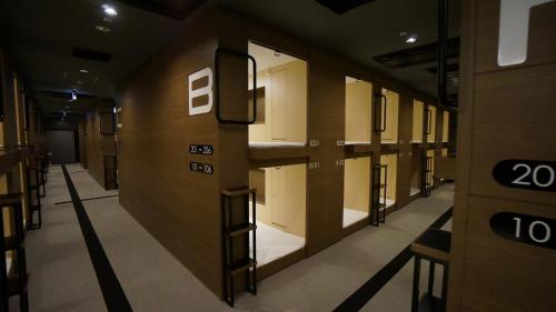 a hallway with rows of lockers in a building at The Bed and Spa (male only) in Tokorozawa