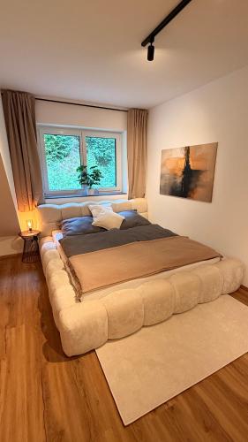 a large bed with a large couch in a bedroom at Das Freyenstein in Berghof
