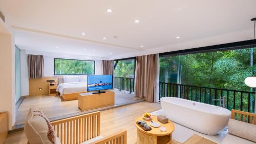 a large room with a bed and a bath tub at HuzhouGiraffe ManorHotel in Huzhou