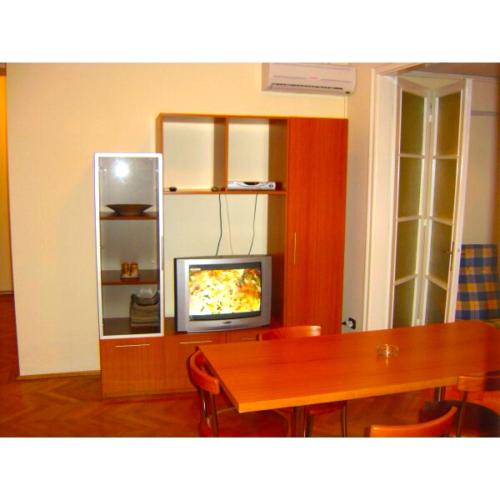 ein Esszimmer mit einem Tisch und einem TV in der Unterkunft Sepcari Old City Apartment in Bukarest