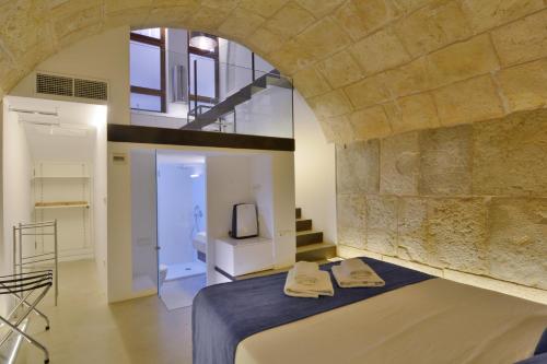 a bedroom with a bed and a stone wall at Lonja Suites Apartments in Palma de Mallorca
