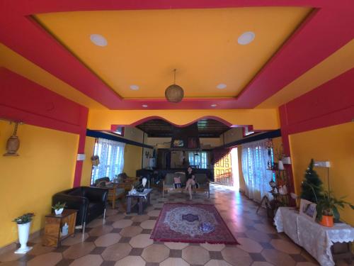 a living room with yellow and red walls at Eya Nest Homestay in Mekha