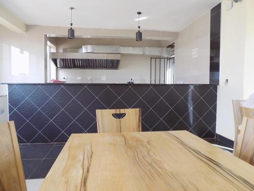 a dining room with a wooden table and chairs at Remmings Hotel Kampala in Kampala