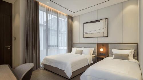 a hotel room with two beds and a window at Alcola Boutique Villa - Dania Unit in Tlekung
