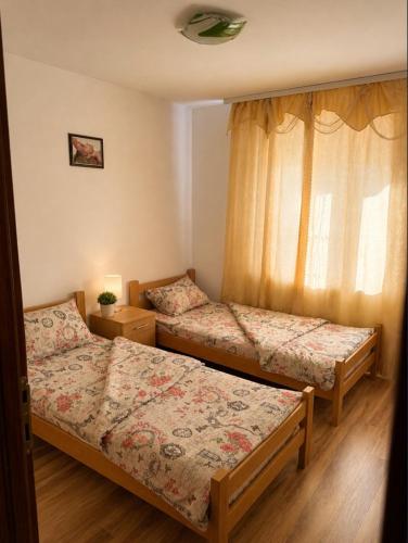 a bedroom with two beds and a window at Shangai apartman in Belgrade