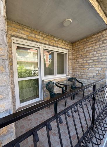 a balcony with two chairs and a table and two windows at Shangai apartman in Belgrade