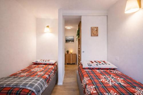 two twin beds in a room with a hallway at Suite Bormio - with WIFI & Netflix in Piatta