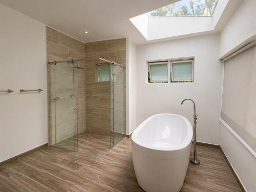 a bathroom with a tub and a glass shower at La Toscana del Poblado in Medellín