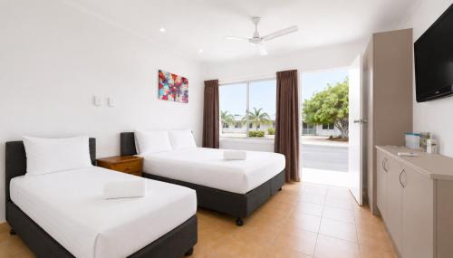 a hotel room with two beds and a television at Motel Ingham in Ingham