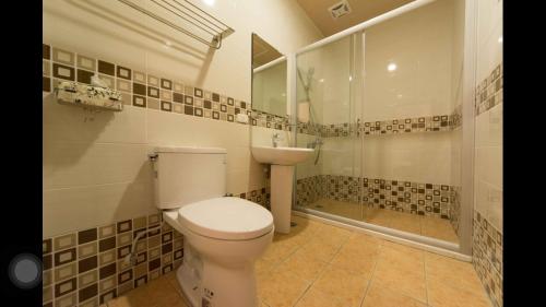 a bathroom with a toilet and a sink and a shower at Kenting Orange Homestay in Hengchun