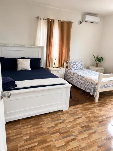 a bedroom with a white bed and a wooden floor at Bon Appetit Hotel & Restaurant Barahona in Santa Cruz de Barahona