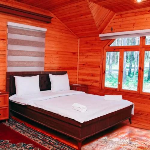 a bedroom with a bed in a log cabin at Narınqala Hotel in Sheki