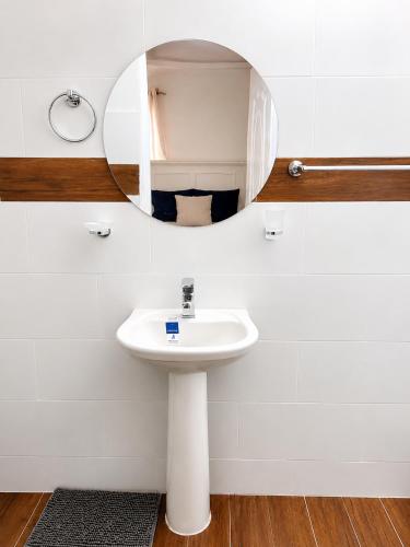 a bathroom with a sink and a mirror at Bon Appetit Hotel & Restaurant Barahona in Santa Cruz de Barahona